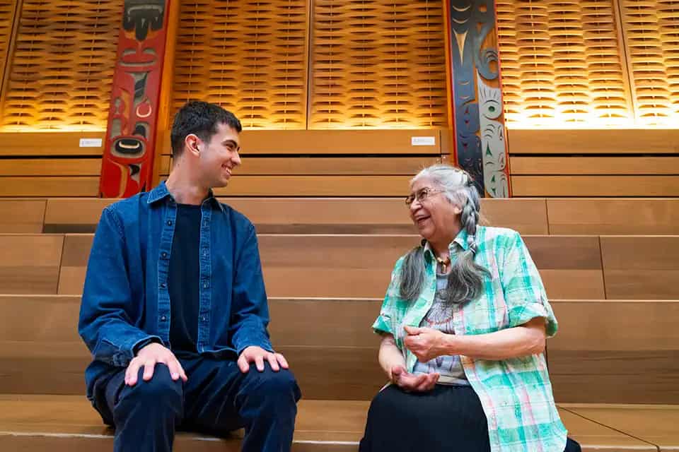 Ryder sits with May Sam, an Elder from the W̱JOȽEȽP (Tsartlip Nation).