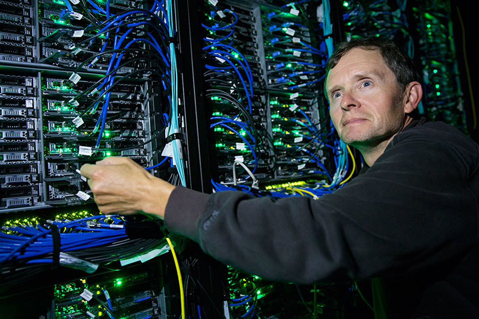 Randall Sobie stands in front of a computer switch board.