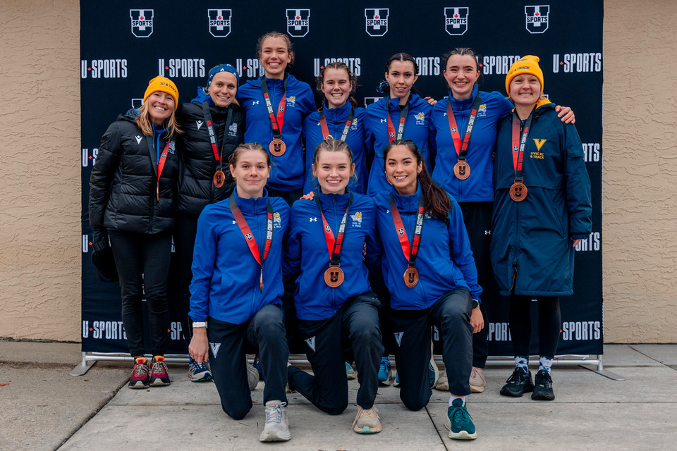 The women's cross country team poses with their bronze medals after finishing third at the U SPORTS national championship.
