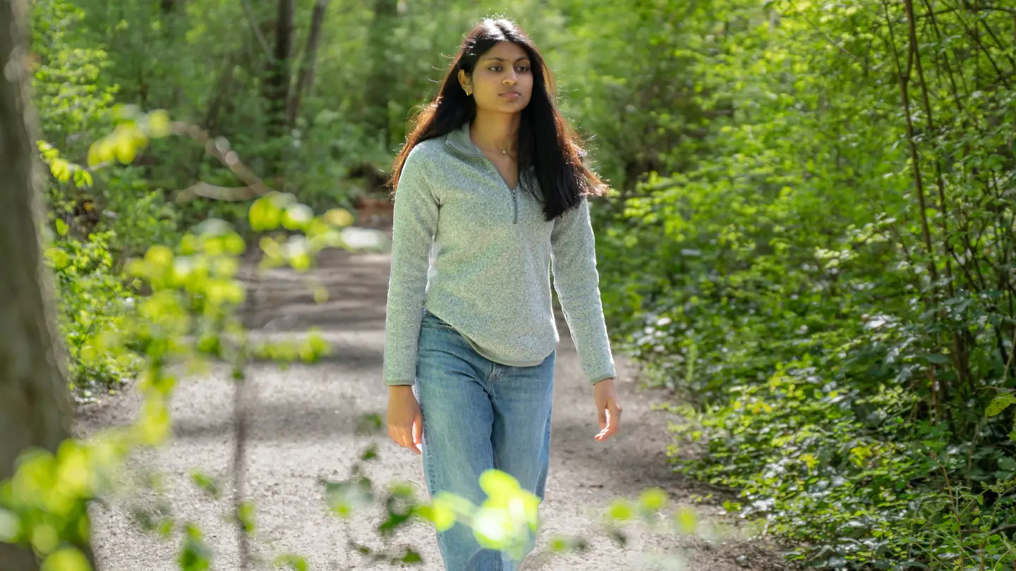 Jaanvi walks through a forsted path on campus. Photo credit: One Island Media