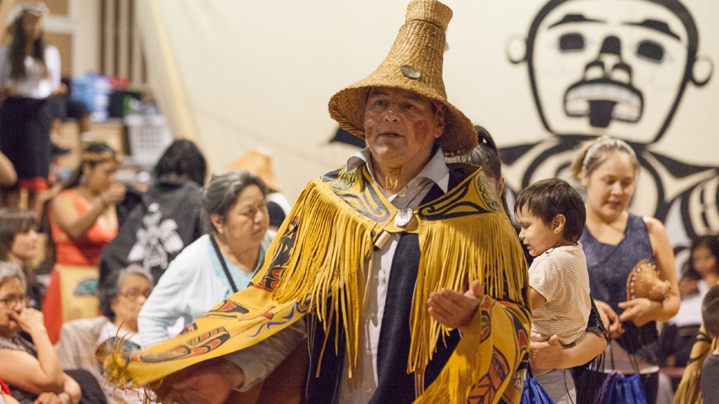 A head and shoulder photo of Hereditary Chief Brown of the Heiltsuk Nation at his family potlatch, wearing a cedar hat and traditional cape.