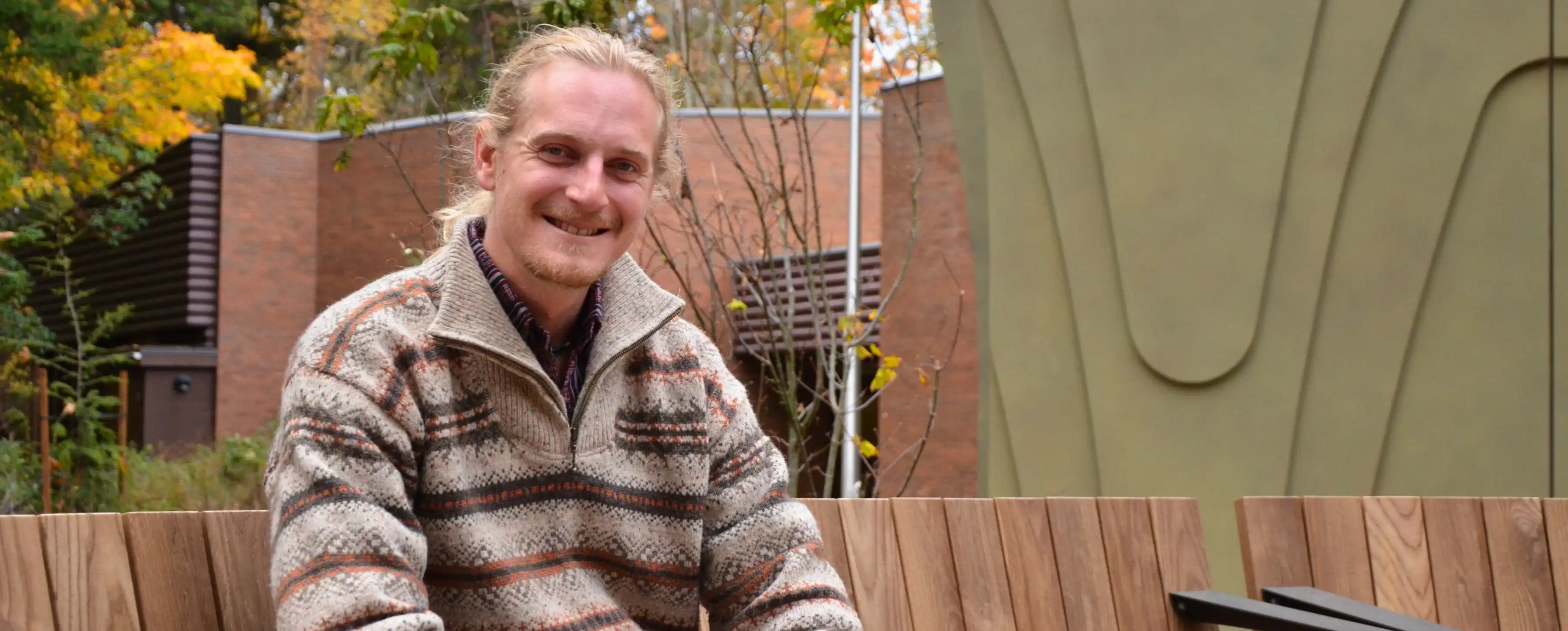 A student sits by the Centre for Indigenous Law at UVic.