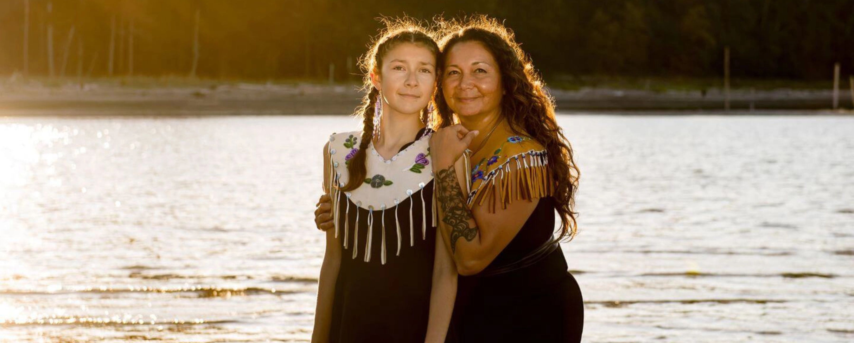 Dani and her mom, Danita embracing in front of a water landscape
