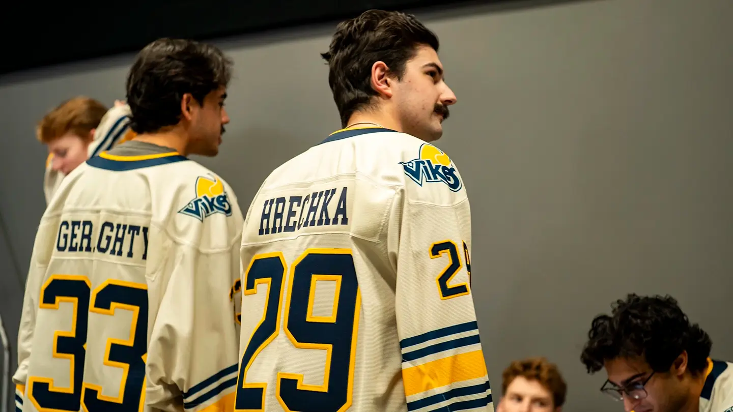 Two men in white jerseys with their backs facing the camera.