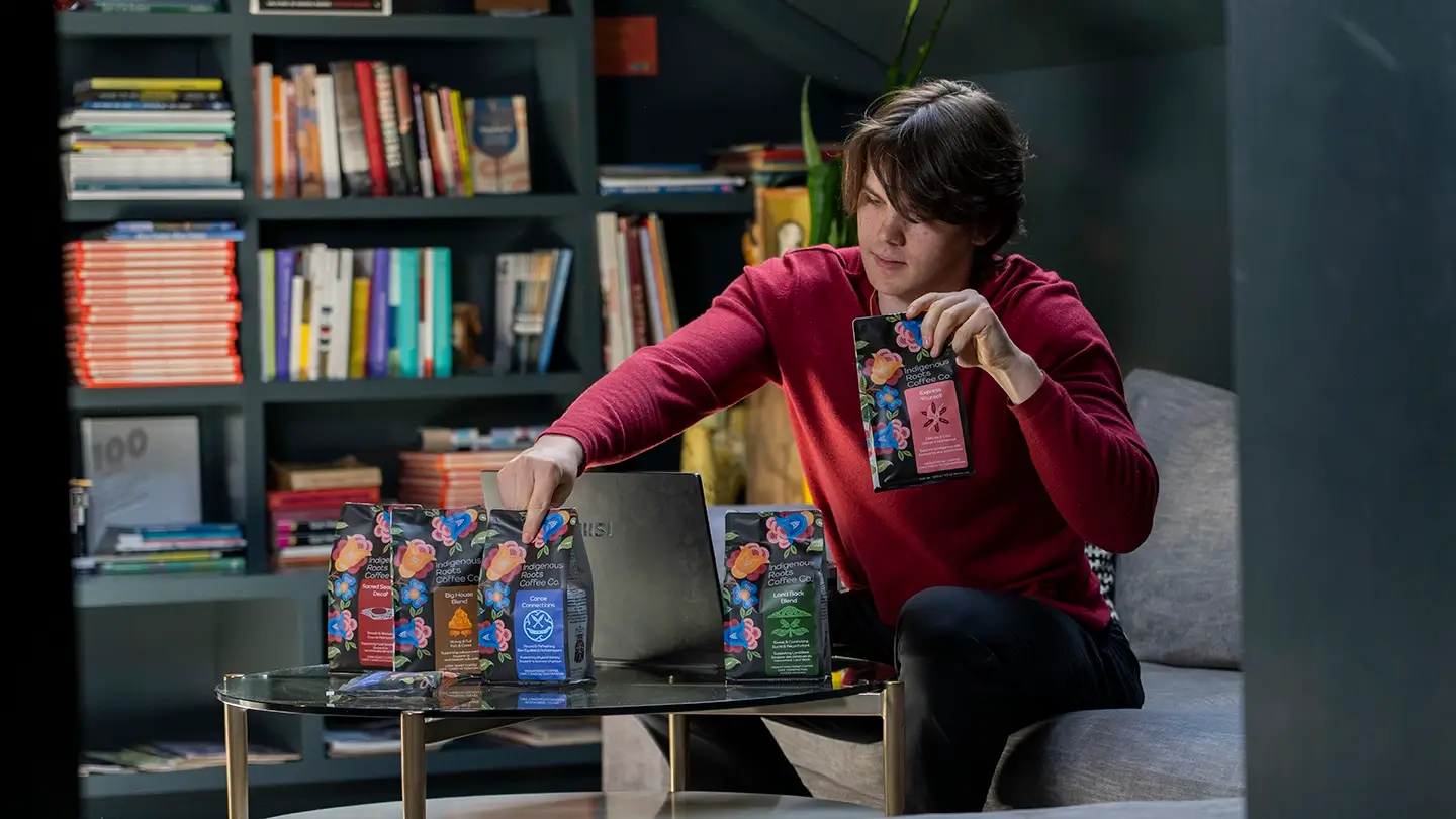 Jack Taylor displays bags of coffee on a table.